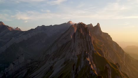 drone flying over hiker on schafler ridge in the appenzell region of the swiss alps in switzerland during sunset