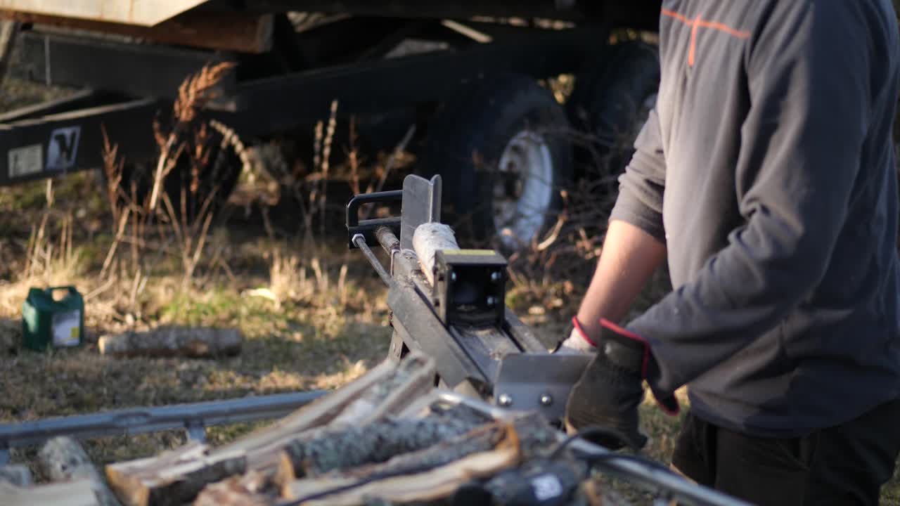 나무를 자르기 위해 통나무 절단기를 사용하는 남자