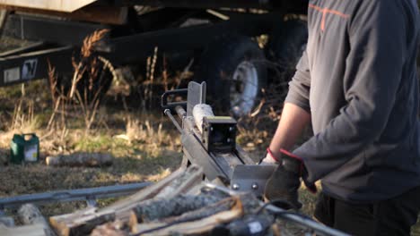 man using log cutting machine for chopping wood