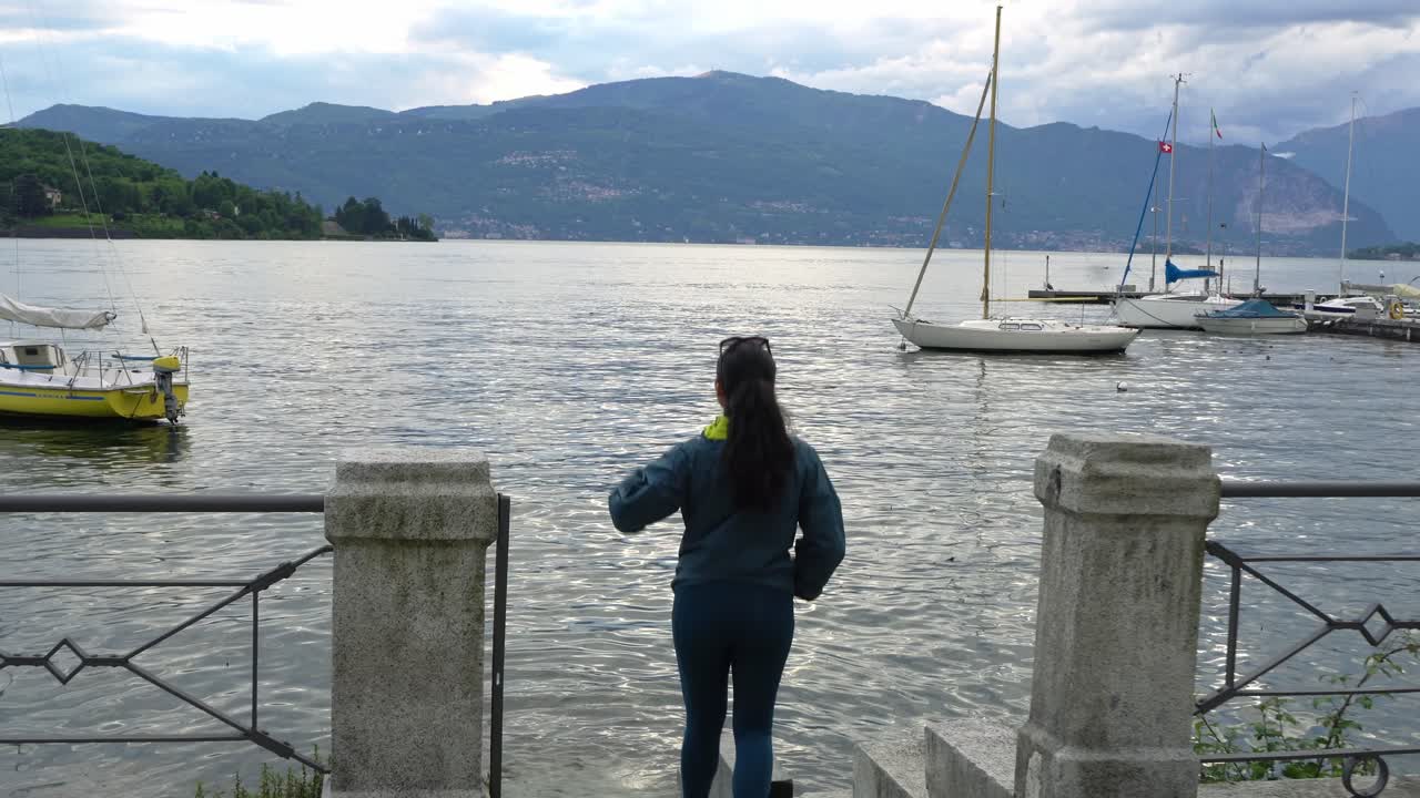 Woman Traveler Walking On The Pier Of Laveno Mombello In Varese, Italy