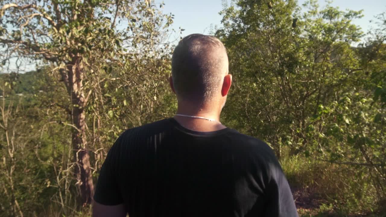 walking behind man going downhill on a nature walk.