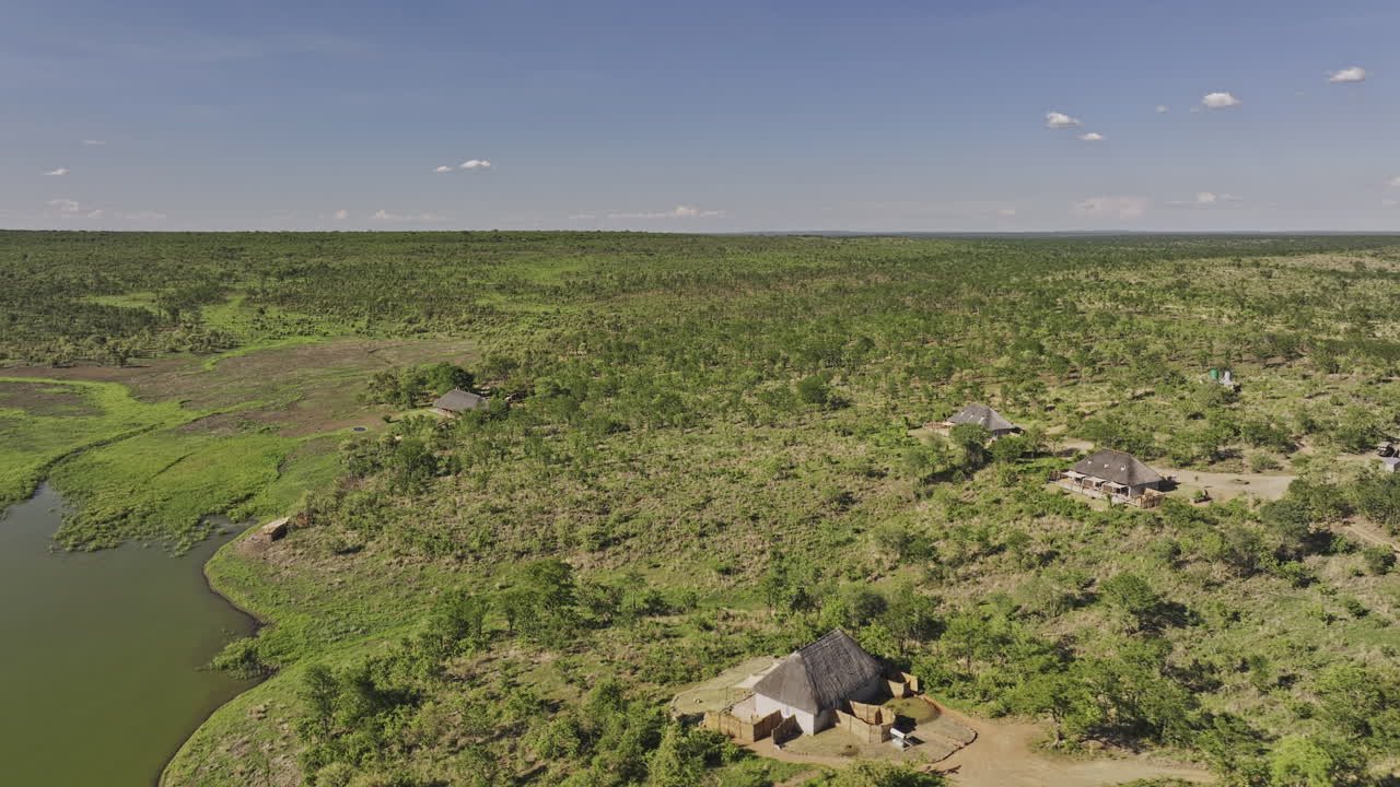 Hwange Park Zimbabwe Aerial v4 flyover around Nantwich safari lodges nestled beside a body of water within a vast, verdant African wilderness - Shot with Mavic 3 Pro Cine - Jan 4th 2024
