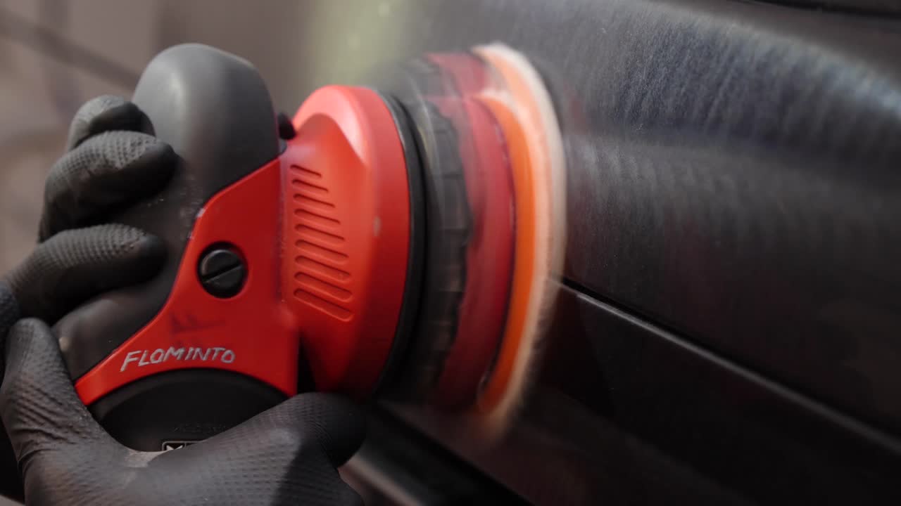 남자 손의 클로즈업 뷰 - 자동차 코팅 품질 관리 - 자동차 바디의 페인트 커버 두께를 측정합니다.