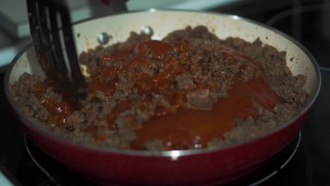 revolviendo carne molida y salsa de tomate en rojo
