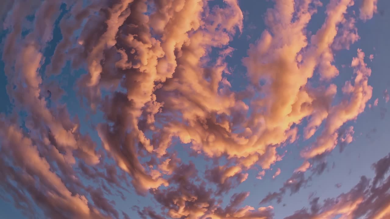 Dramatic swirling clouds in a sunset sky, captured from a low-angle perspective, evoke a surreal