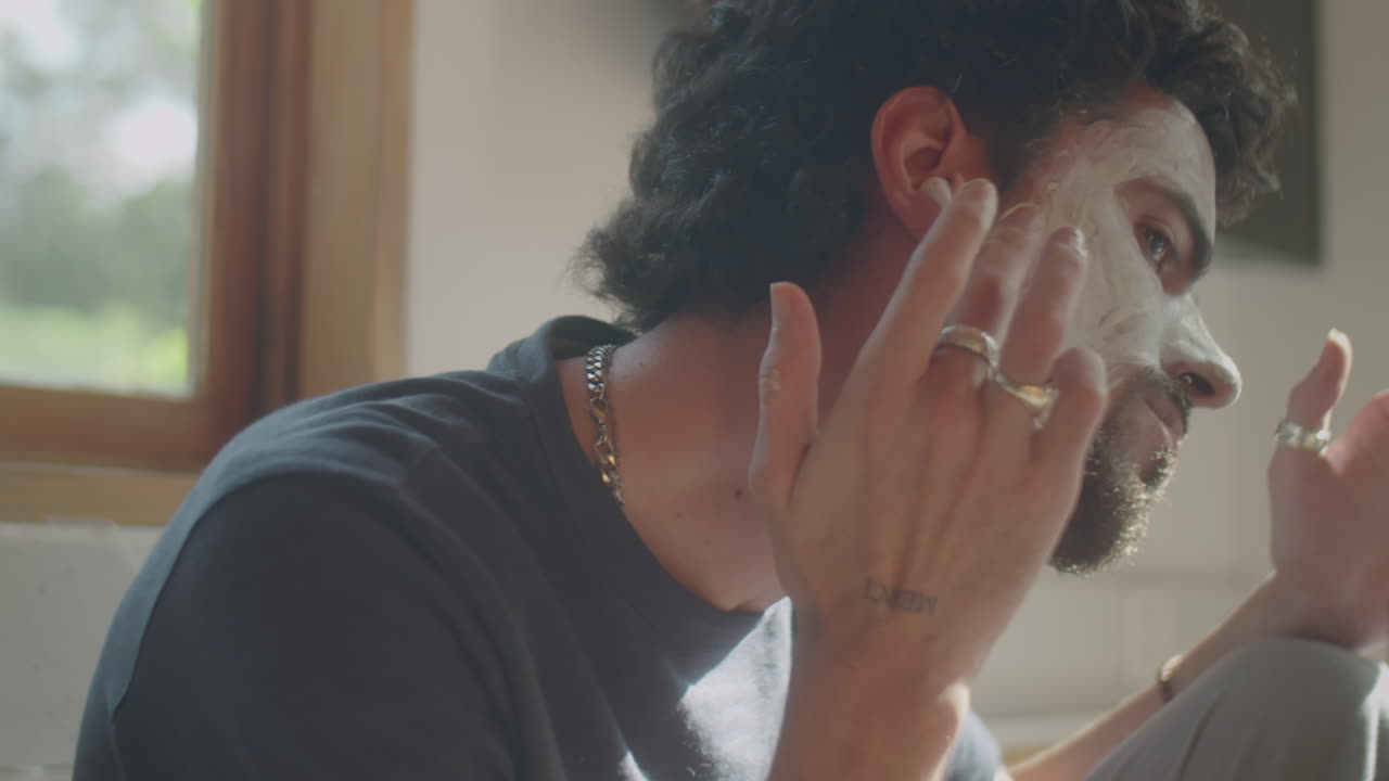 Man in Earphones Using Face Mask at Home