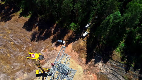 construcción de torres de pilones eléctricos con grúa en un bosque