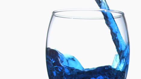 blue trickle in super slow motion flowing in a glass