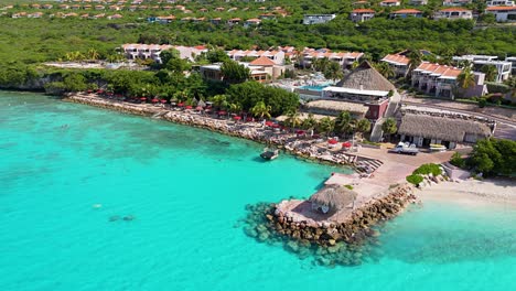 drone right to left orbit around clear caribbean waters splashing against karakter beach's white sand