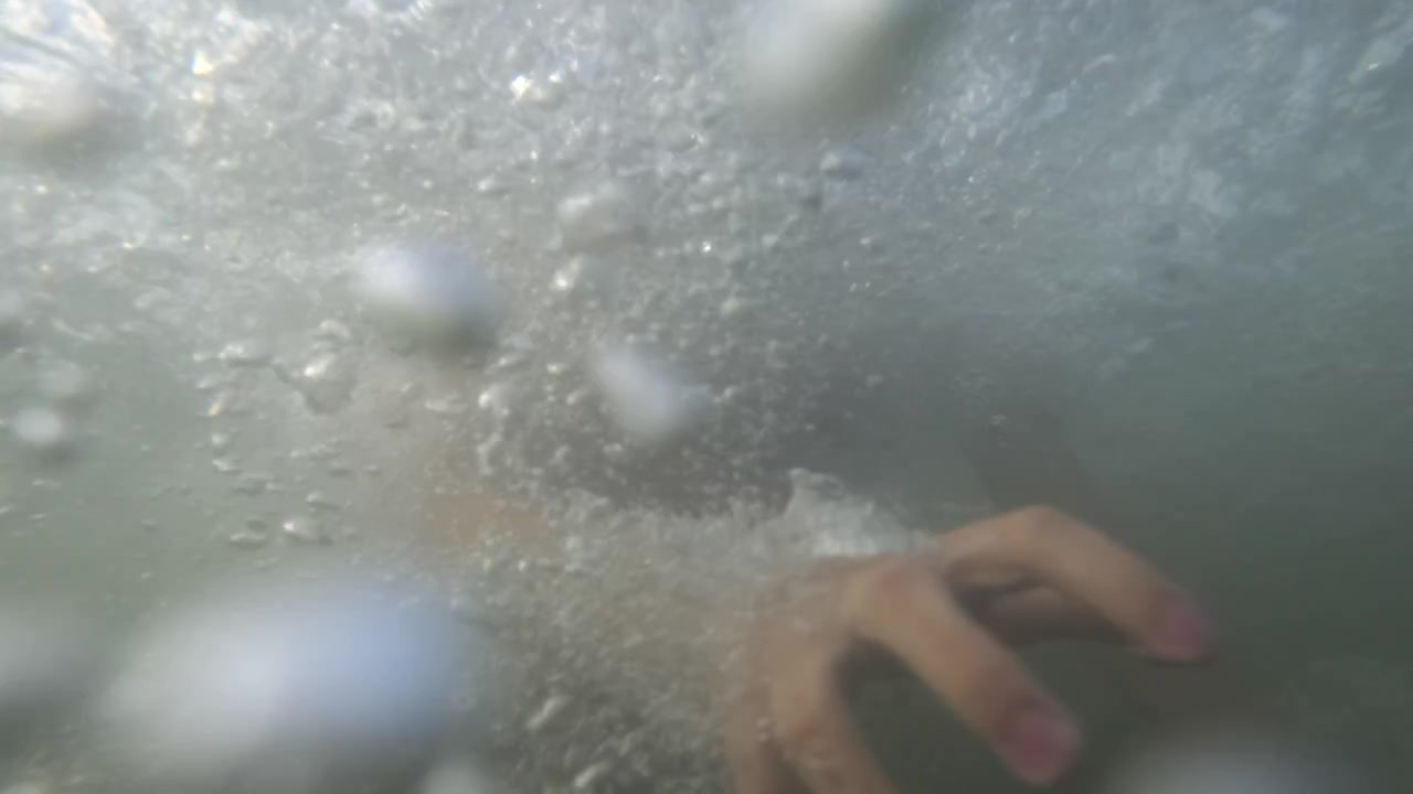 Vista subacquea di bolle che salgono intorno al braccio di un nuotatore mentre si immerge sotto la superficie, Golfe-Juan, Francia