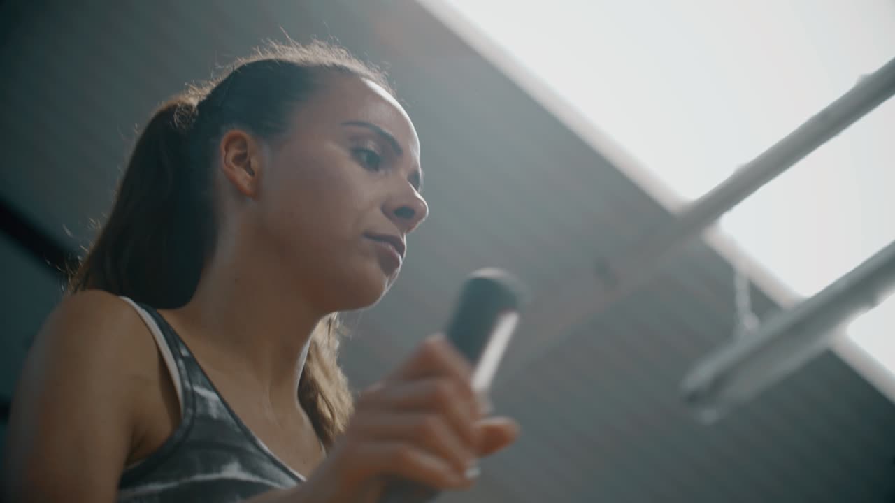 Woman Using Running Machine in Gym