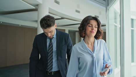 disappointed business people hearing bad news smartphone walking office closeup