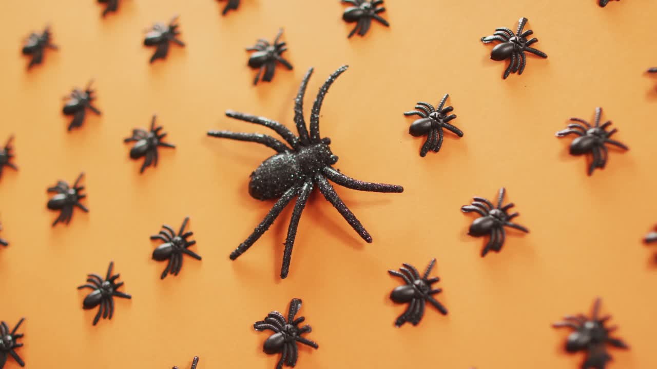 vista de cerca de varios juguetes de araña contra un fondo naranja