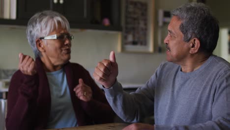 happy senior mixed race couple signing document and embracing