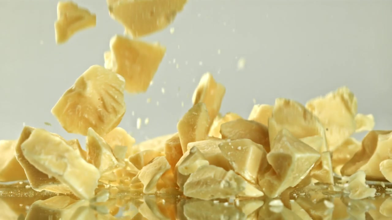 Raw Cocoa Butter Chunks Falling in Slow Motion
