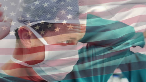 animación de agitar la bandera de los estados unidos sobre un cirujano caucásico que lleva una máscara quirúrgica en el hospital