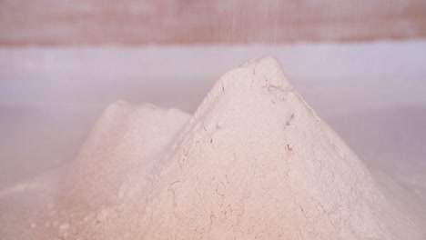 wheat flour pouring from millstone after grinding