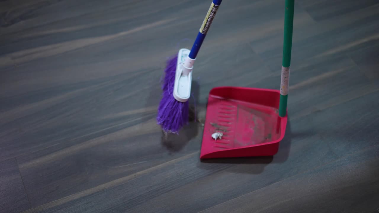 recogiendo basura del suelo con la pala y la escoba