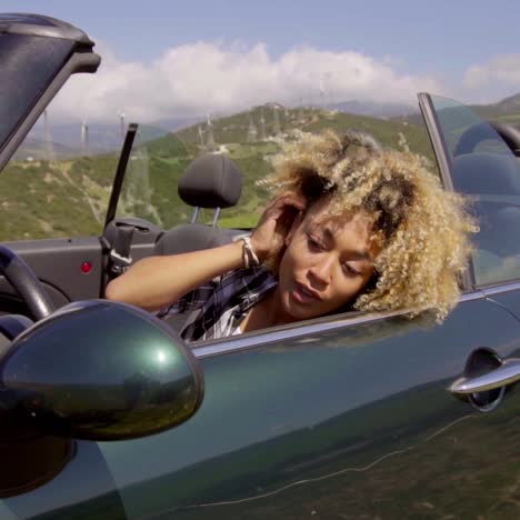 young woman sitting in parked cabriolet