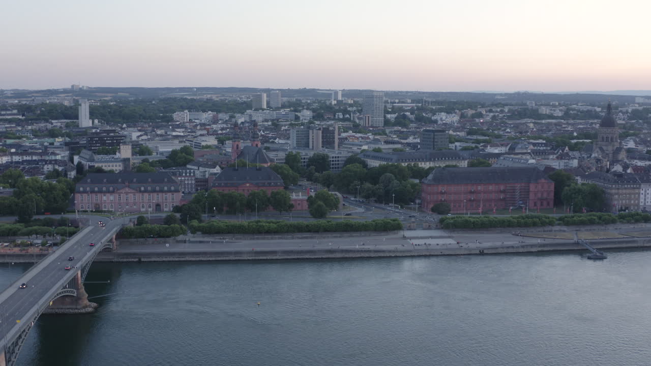 Aerial circling Drone View over Mainz Rhine River, Castle, dom, Theodor Heuss Bridge and Cityscape at Sunset Germany