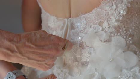 bride getting ready: someone zipping up her wedding dress