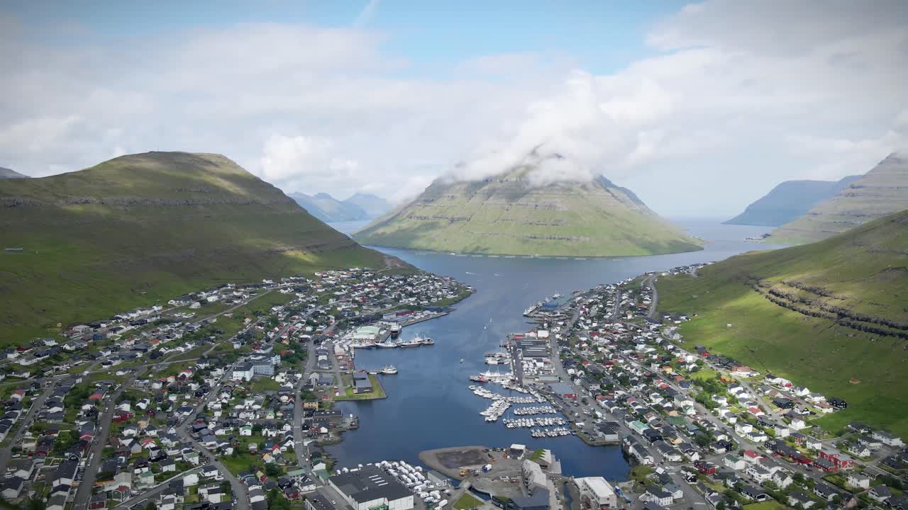 페로 제도의 두 번째로 큰 도시인 클라크스비크는 산과 피오르드 사이에 자리 잡고 있으며, 낮은 구름이 산꼭대기를 고 극적인 분위기를 조성합니다.
