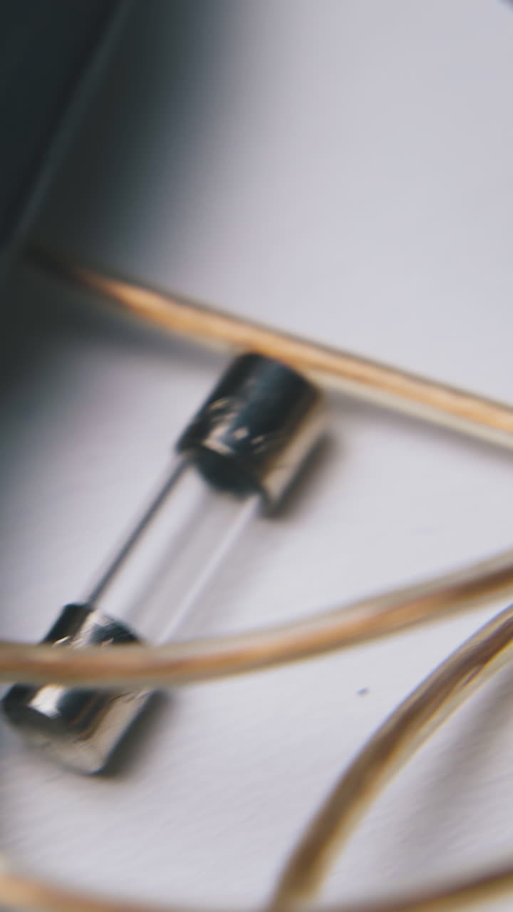 set with different wires and glass cartridge fuses lies on clean white background extreme close view