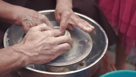 abuela con unos nietos hacen jarras en cerámica