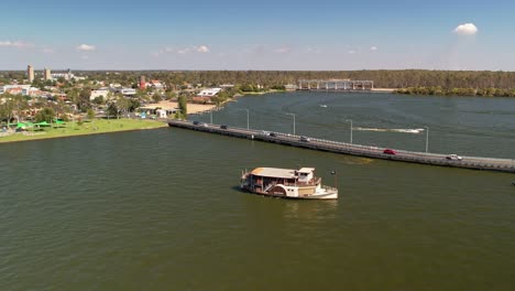 The-paddle-steamer-Cumberoona-moving-alongside-the-bridge-at-Yarrawonga,-Victoria,-Australia