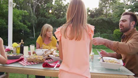 Three-generation-family-enjoying-lunch-outdoors