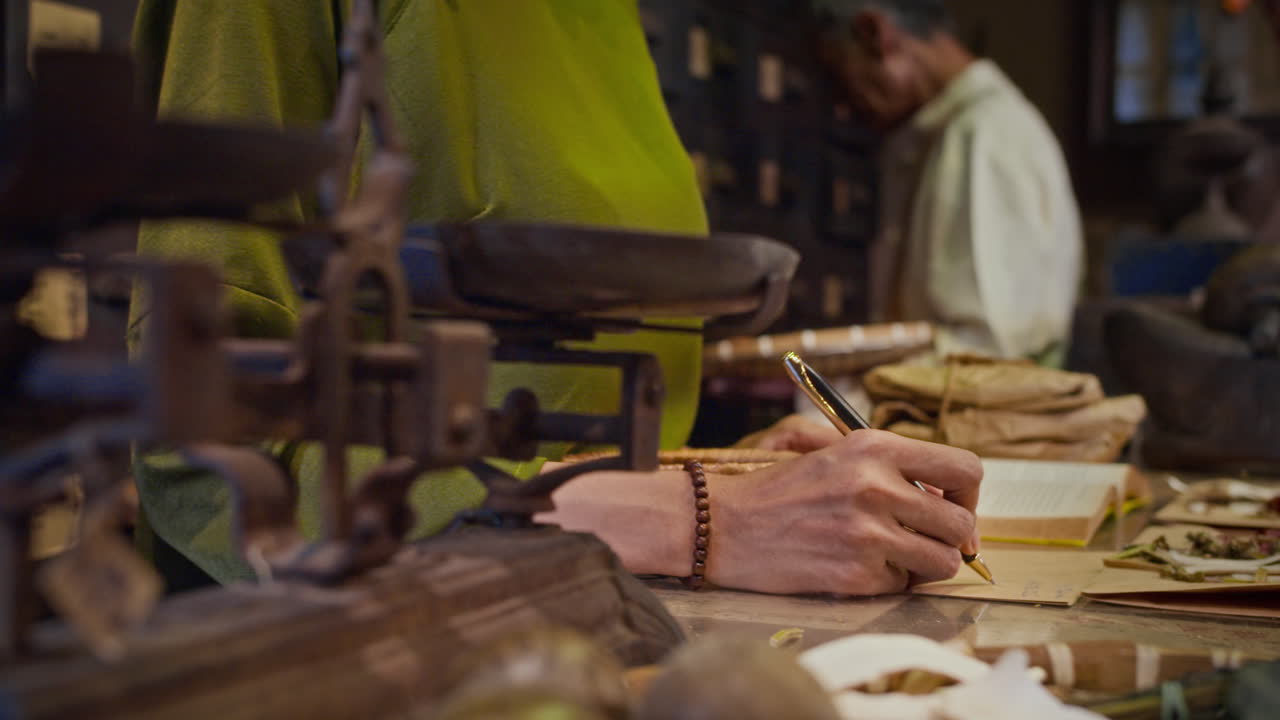 Hands of Alternative Medicine Pharmacy Worker Listing Ingredients on Paper
