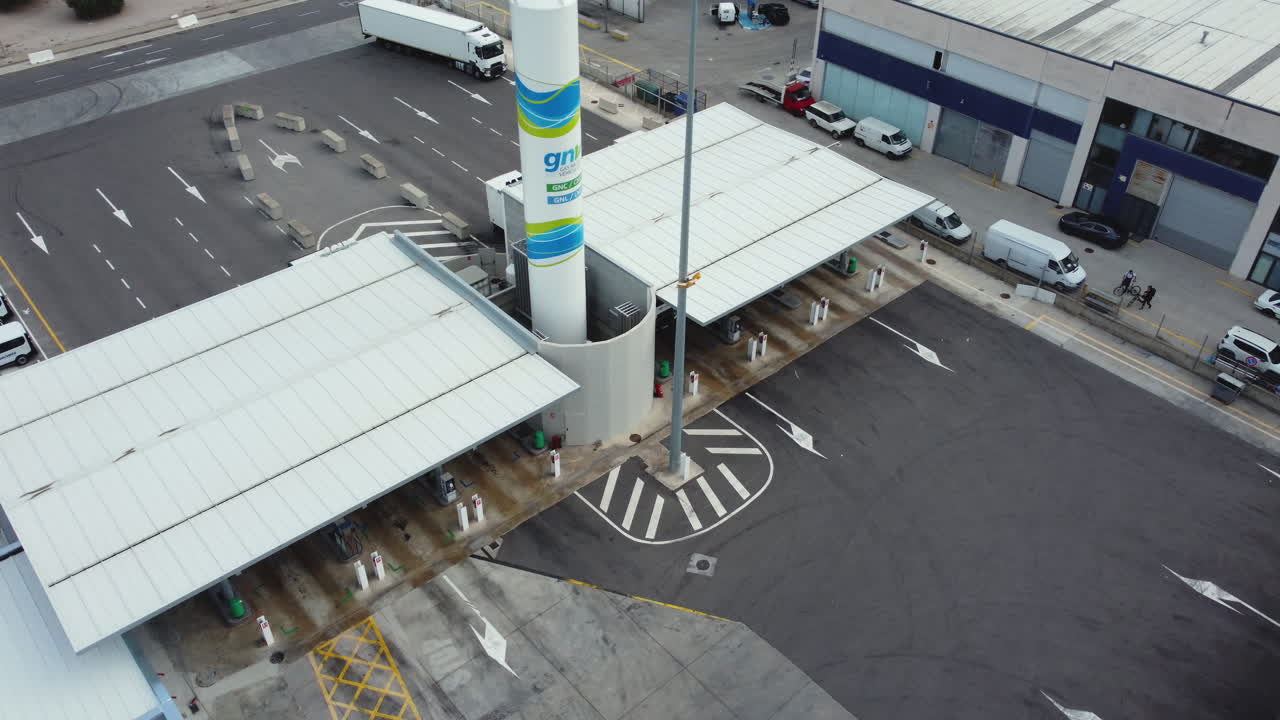 Luftfoto af en moderne tankstation og lastbilrasteplads i et industriområde