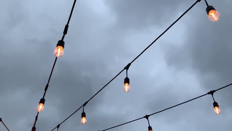 Luces-De-Patio-Al-Aire-Libre-Que-Iluminan-El-Cielo-En-Una-Noche-Lluviosa-Y-Sombría