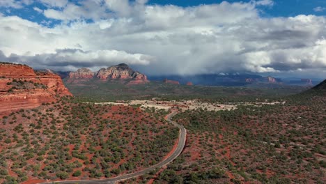 vista of nature with rock formations and arid forest against cloudscape in sedona, arizona