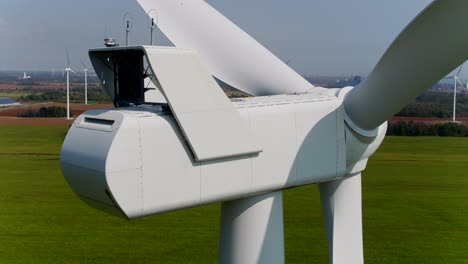 wind turbine nacelle rear view with propellers from an aerial drone panning shot for inspection