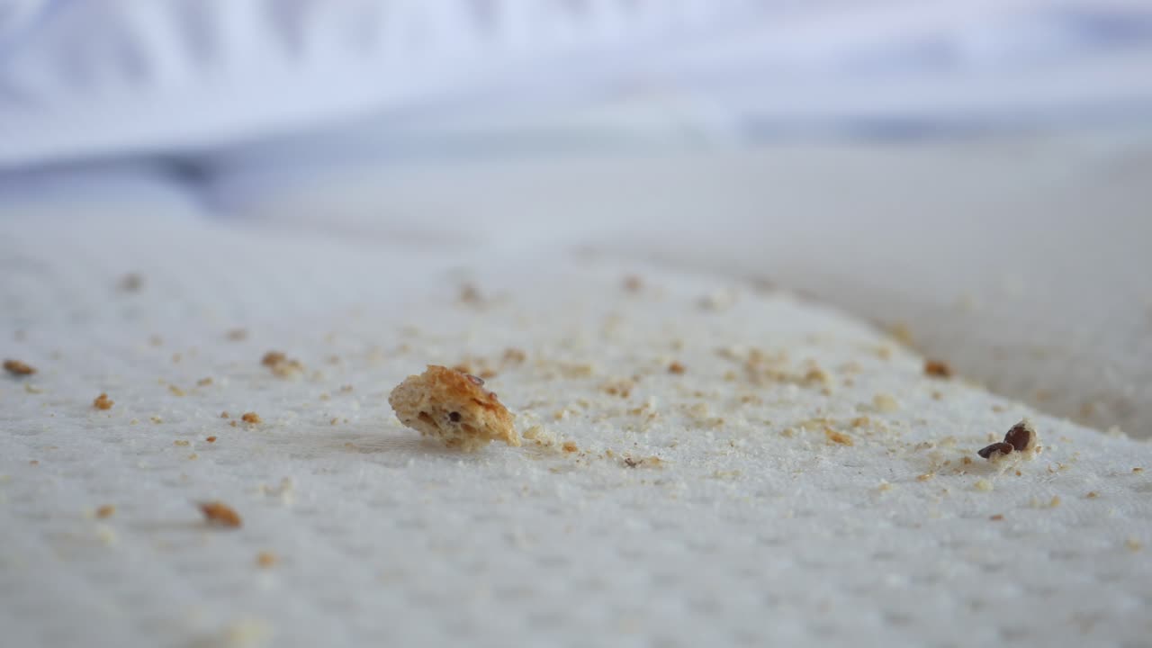 cerca de las migas de pan en una sábana blanca