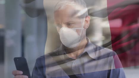 Animation-of-flag-of-france-waving-over-caucasian-man-wearing-face-mask-in-city-street