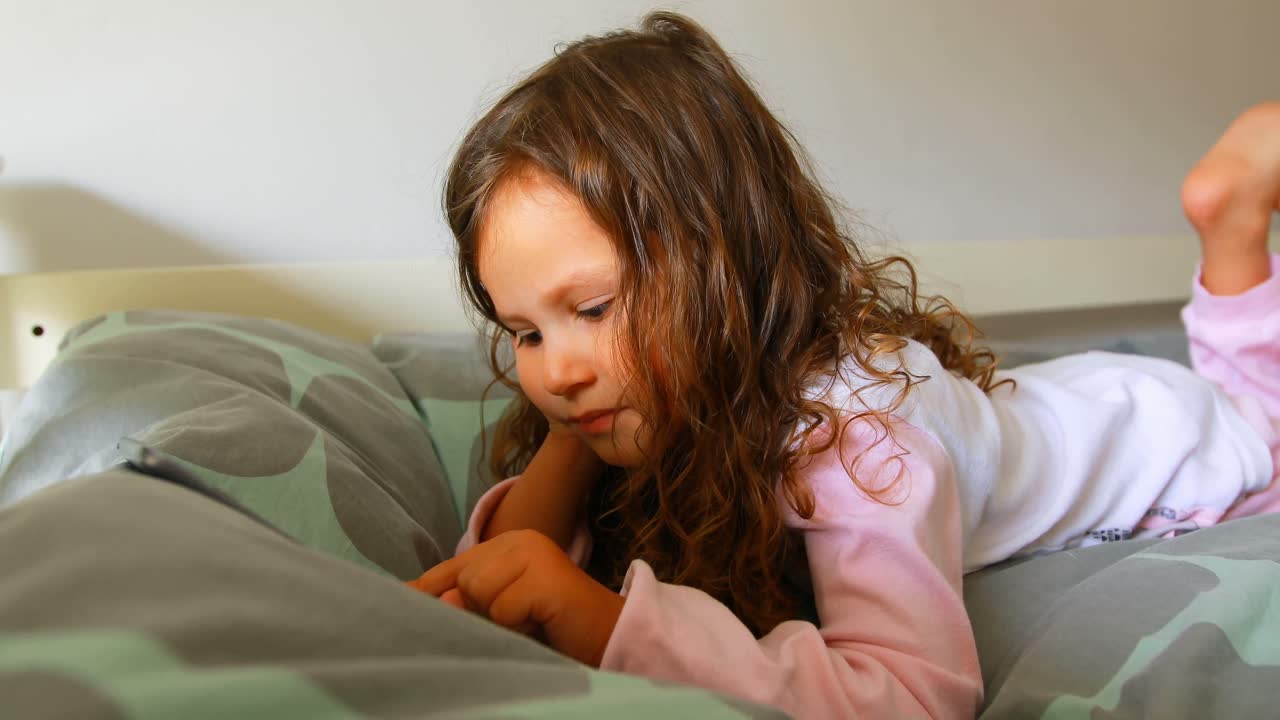 chica usando tableta digital en el dormitorio 4k