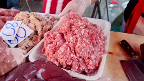 hands shaping ground meat on a butcher's block