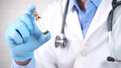 médico que sostiene el vial de la vacuna contra la covid-19