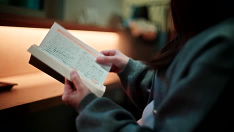 mujer leyendo un libro en un café