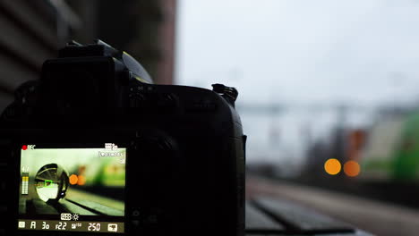 display of camera recoding video with crystal ball reflects a passing train at station