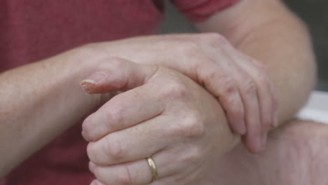 adult hands slowly rubbing together over cracked and blistered skin, close up