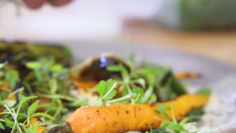 sprinkling cress over the top of healthy fine dining dish