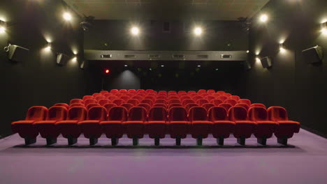 global view of a small empty movie theater. cinema room with red seats