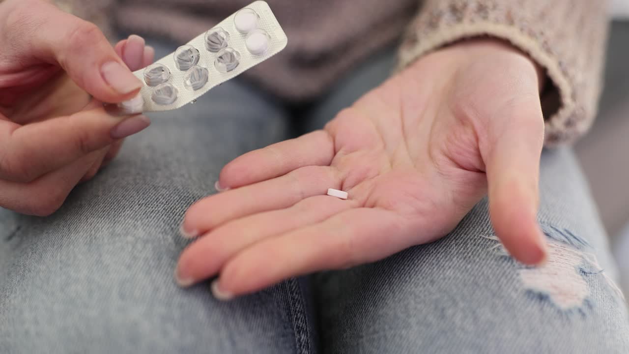 Person taking a pill from a blister pack