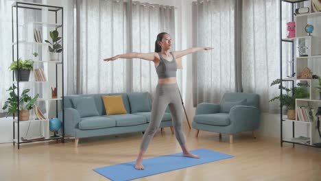 joven atleta asiática con ropa deportiva estirándose y practicando yoga en casa. estilo de vida saludable, fitness, bienestar y concepto de atención plena