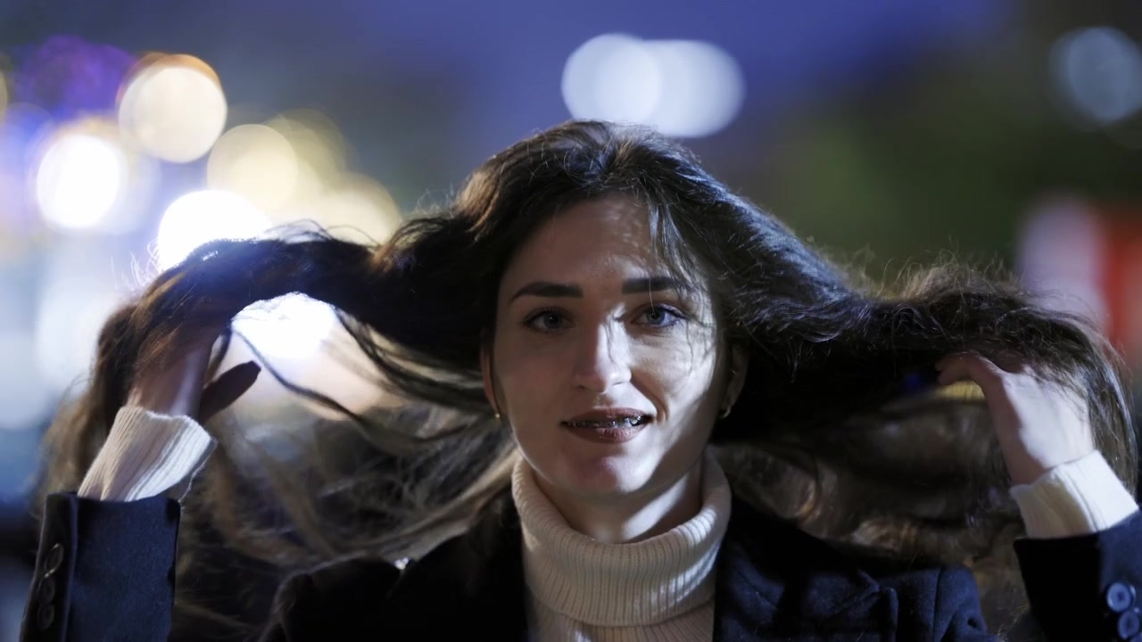 Ritratto di una bella donna che sorride di notte in città