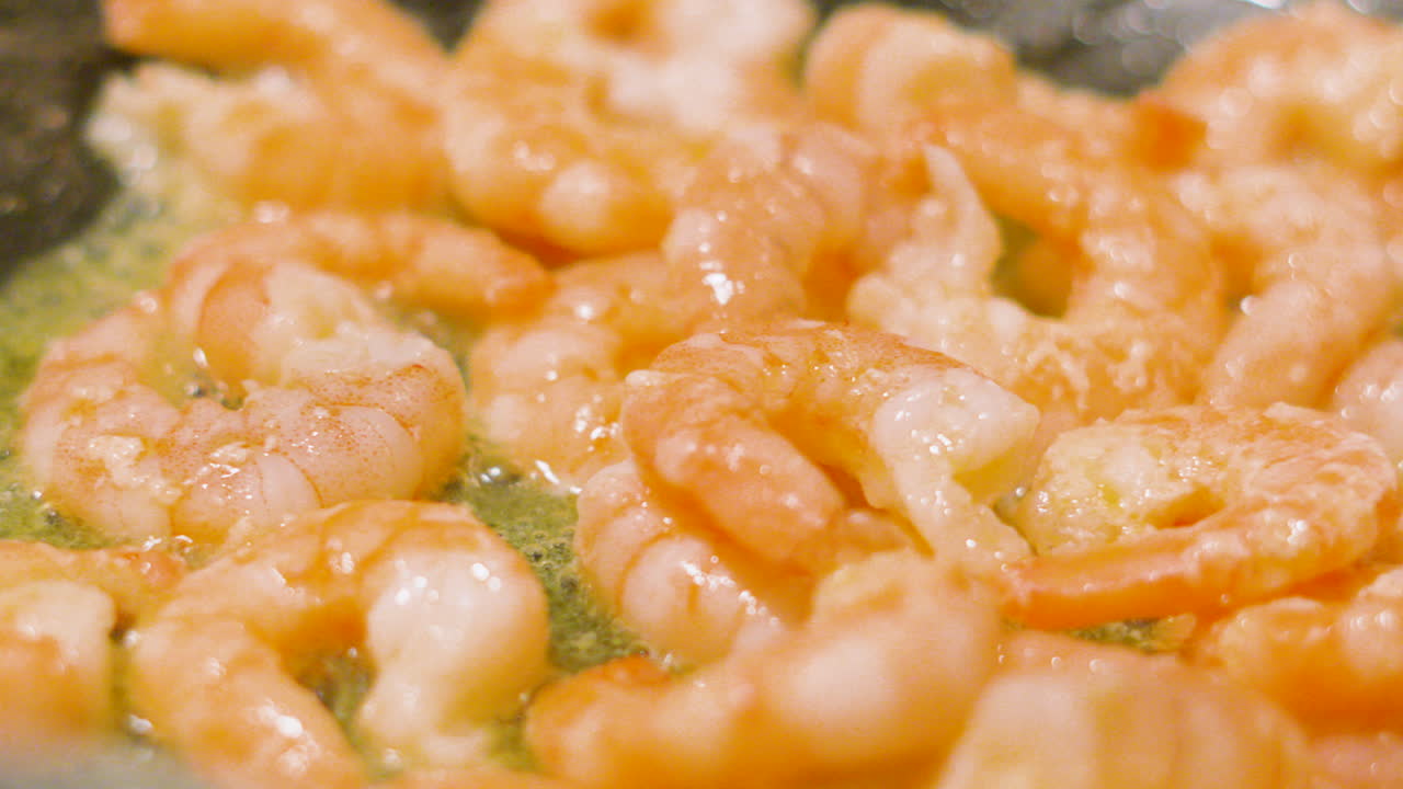 King Prawns Gently Sizzling in Pan with Olive Oil Bubbling Underneath. Slow Motion Close Up Shellfish Seafood. Tasty Starter or Main Dish