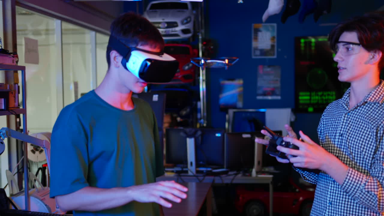 Young engineers with VR virtual reality headset controlling fliying drone in research laboratory, slow motion